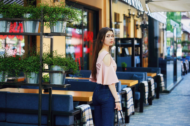 Portrait of a young girl in the city . Girl in jeans and blouse on the streets - Foto, Imagem