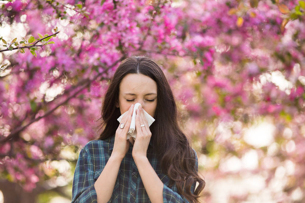 Woman blowing nose because of spring pollen allergy - Photo, Image