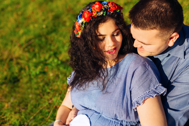 der Ehemann umarmt seine schwangere Frau vor dem Hintergrund der gre - Foto, Bild