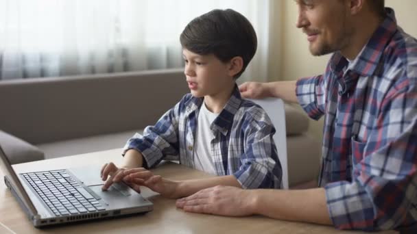 Proud father and his son shopping online on laptop computer, technologies - Video, Çekim