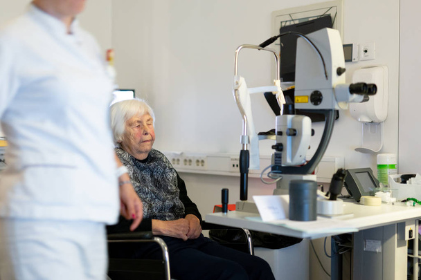 Mujer mayor siendo preparada para cirugía láser en clínica de oftalmología
. - Foto, imagen