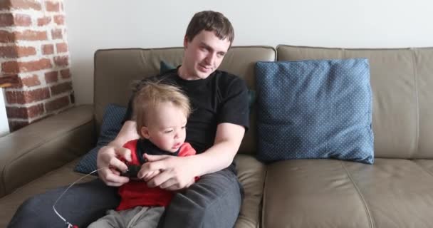 Dady και μωρό αγόρι που παίζει με το παιχνίδι αυτοκίνητο ραδιόφωνο ελέγχου - Πλάνα, βίντεο
