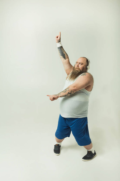 Excited fat man dancing with headphones - Foto, Imagen