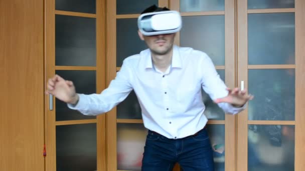 Homem vestindo fone de ouvido VR na sala de estar. Usando gestos com as mãos
. - Filmagem, Vídeo