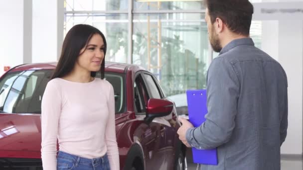 Preciosa mujer feliz estrechando la mano con concesionario de coches después de recibir las llaves del coche
 - Imágenes, Vídeo