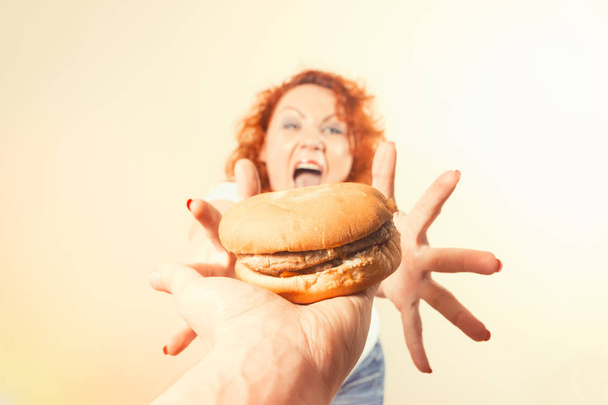 Велика жінка їсть фаст-фуд. Червоне волосся товста дівчина з бургер. Здоров'я
 - Фото, зображення