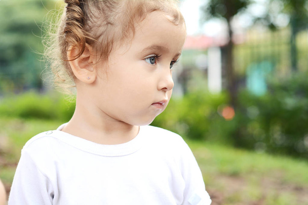Portrait of baby girl in park. - Foto, afbeelding