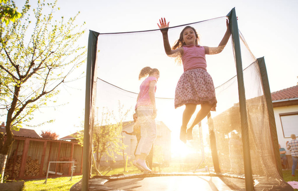  kolme suloinen leikkisä lapset hyppäämällä trampoliini ulkona
  - Valokuva, kuva