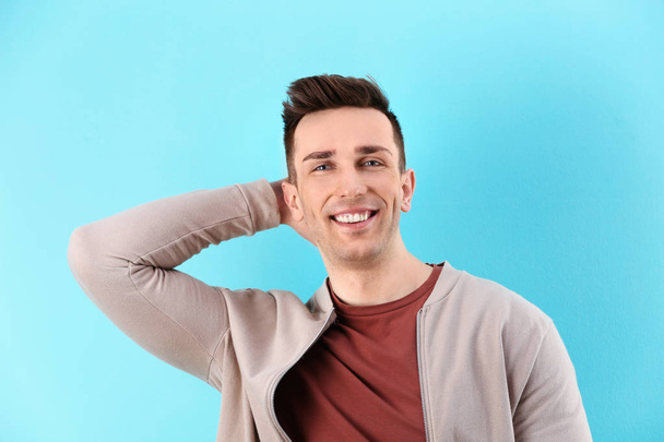 Charming young man on color background - Foto, Imagen