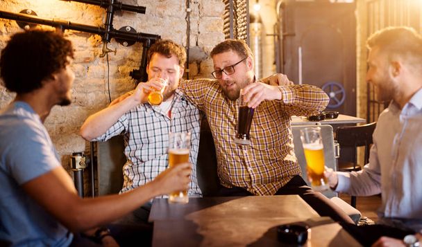 mladí rádi vousatých mužů pití piva v hospodě a baví - Fotografie, Obrázek