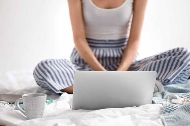 Female blogger with laptop on bed - Фото, изображение