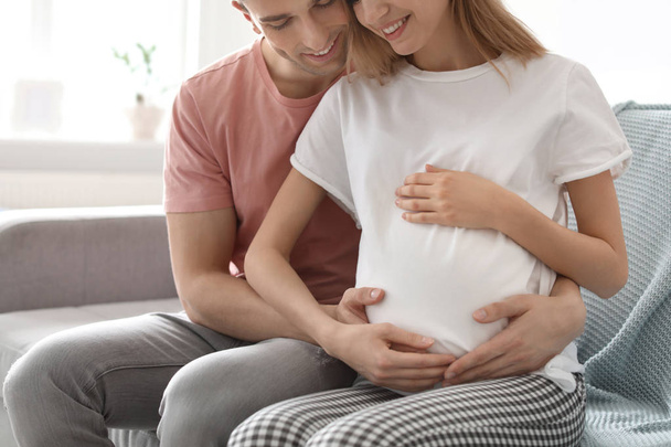 Young pregnant woman with her husband at home - Foto, afbeelding
