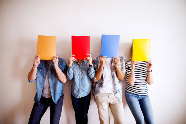 group of young people, covering faces with colorful folders  - Φωτογραφία, εικόνα