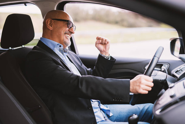 happy mature elegant businessman in suit driving a car  - Foto, Bild