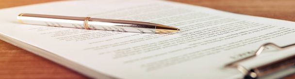 Pen lying on a contract or application form, wide angle view. - Foto, imagen
