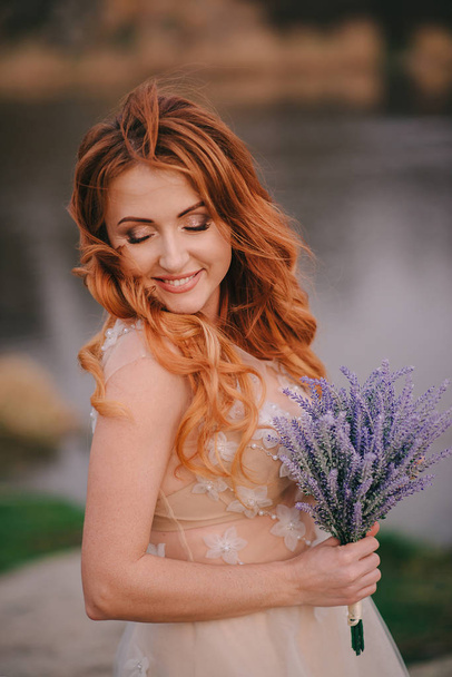 portrait of a young red-haired woman with flowers in hands, close-up - Photo, image