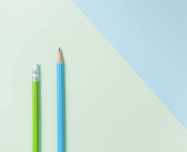 Зелений олівець і синій олівець на зеленому і світло-блакитному фоні
. - Фото, зображення
