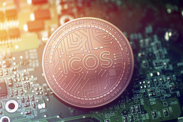 shiny copper ICOS cryptocurrency coin on blurry motherboard background - Photo, Image