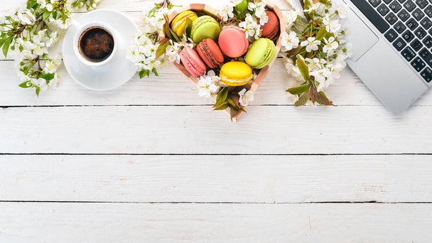 Macaroons and a fragrant cup of coffee. Top view. On a wooden background. Copy space. - Foto, afbeelding