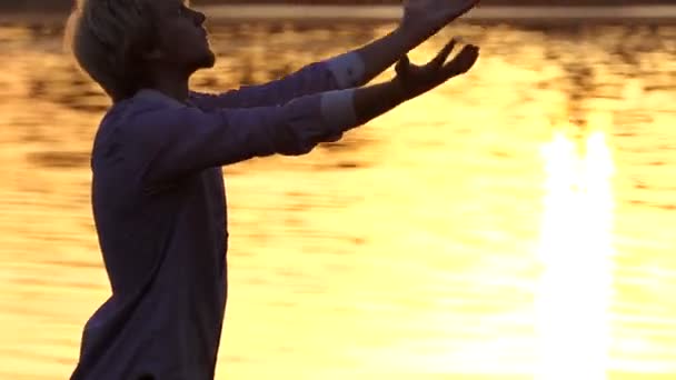 Europejskich człowiek praktyk jogi na korzenie drzew o zachodzie słońca - Materiał filmowy, wideo