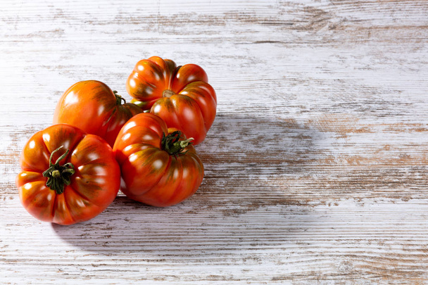 rode tomaten op een houten tafel - Foto, afbeelding