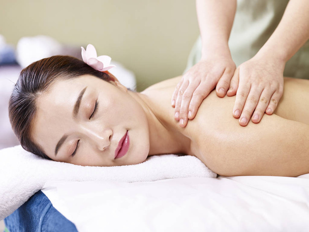 красива молода азіатська жінка отримує масаж в спа-салоні
 - Фото, зображення