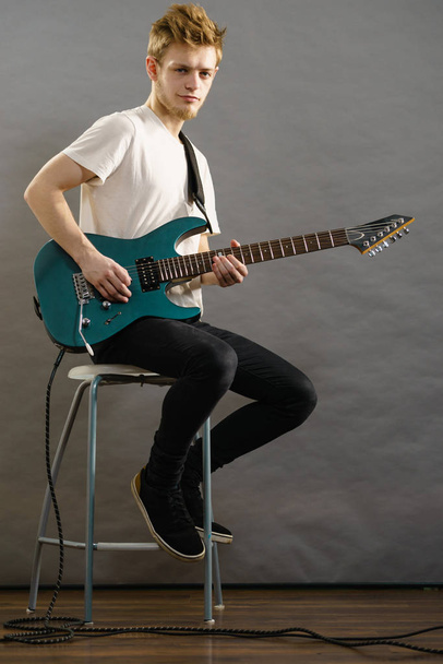 Young man playing electric guitar - Fotó, kép