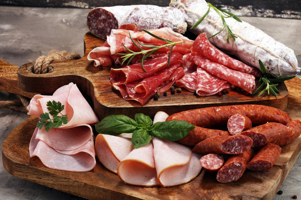 Food tray with delicious salami, ham,  fresh sausages and herbs. - Фото, зображення