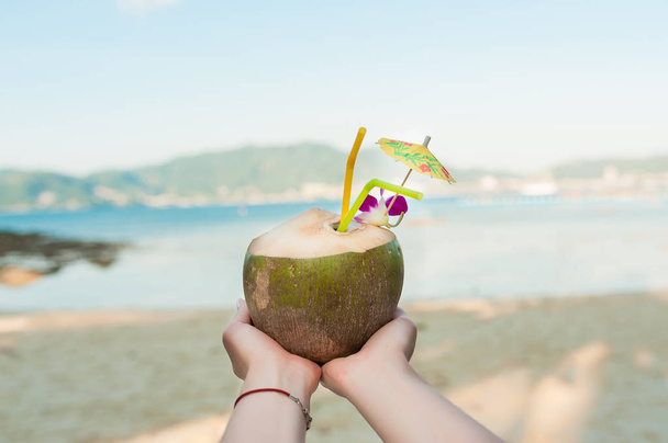 Frau hält Kokosnusscocktail in der Hand - Foto, Bild