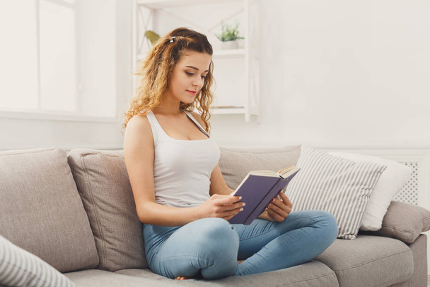 Cozy home. Young thoughtful woman with book - Foto, Bild