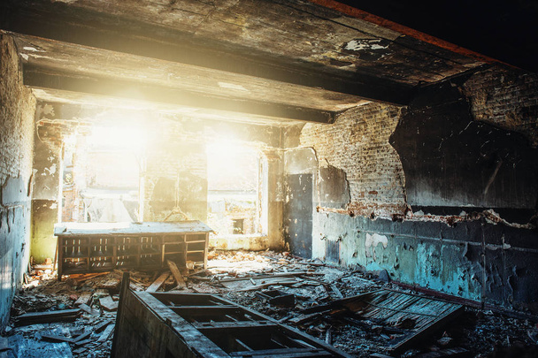 Ruins of old abandoned building, damaged in war, inside destroyed room with sunlight, disaster and devastation concept, broken walls and furniture - Photo, Image