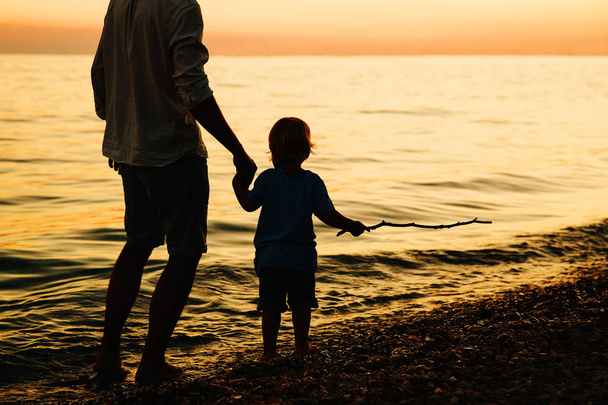 Vater und Sohn gehen am Meer spazieren. - Foto, Bild