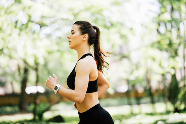 Mosolygós, sportos nő fut kint a szabadban park - Fotó, kép