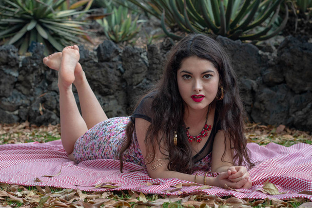 Hermosa joven latina relajándose en el parque vistiendo apretado y rosa vestido de primavera
 - Foto, Imagen