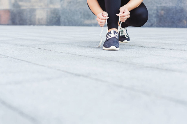 Frau bindet vor dem Laufen Schnürschuhe - Foto, Bild