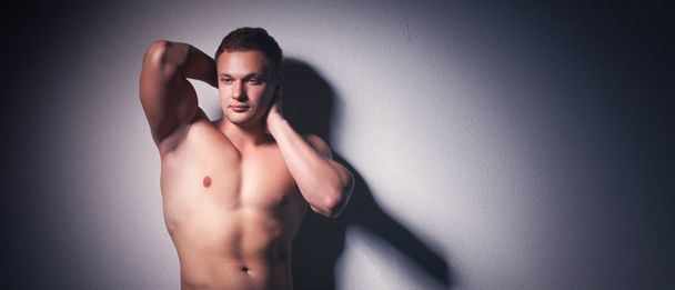 Healthy muscular young man. Isolated on black background - Valokuva, kuva