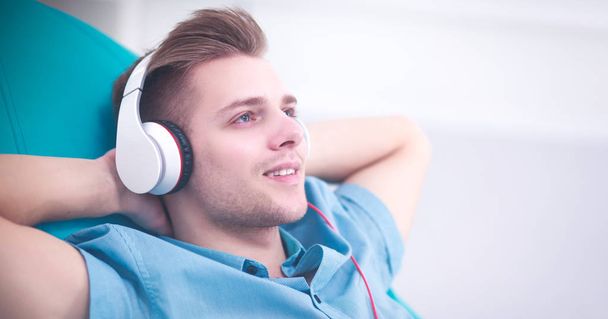 Man luisteren muziek met koptelefoon thuis - Foto, afbeelding