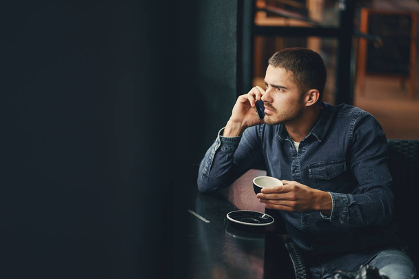 muž používající telefon uvnitř restaurace - Fotografie, Obrázek