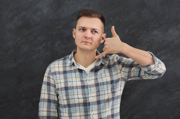 Attractive man making call me gesture - Photo, Image
