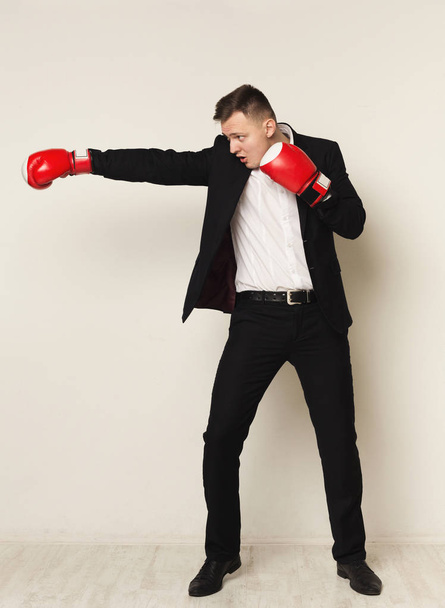 Επιχειρηματίας σε κόκκινο γάντι πυγμαχίας γροθιά στο στόχο - Φωτογραφία, εικόνα