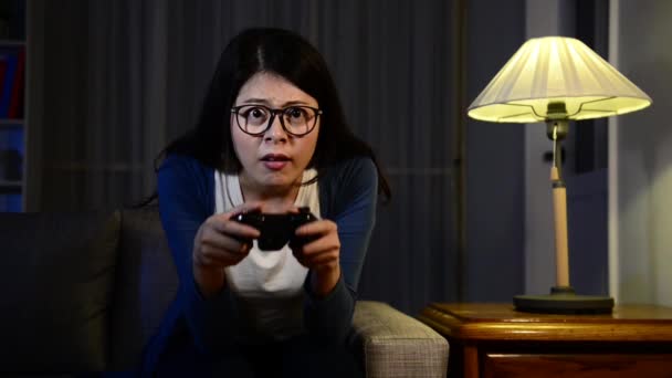 pretty elegant woman playing online video game with joystick control and showing lose depressed looking at television challenge difficulty level plot at night. - Video, Çekim