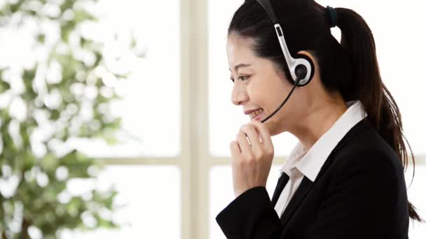 Азиатская служба поддержки клиентов женщина онлайн телефонный звонок, чтобы помочь клиенту с гарнитурой в офисе
 - Кадры, видео