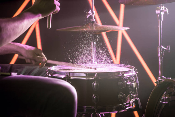 男は、色のライトの背景に、ドラムを果たしています。 - 写真・画像