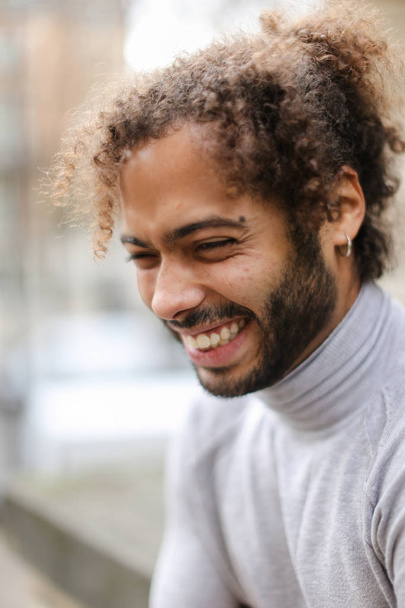 Close-up van gezicht van afro-Amerikaanse mannelijke persoon met bruin krullend haar. - Foto, afbeelding
