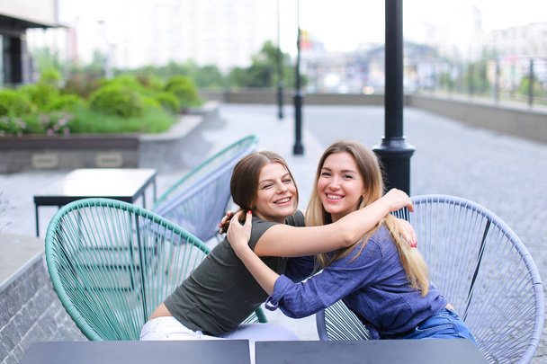 Femmes souriantes assises au café à l'extérieur
. - Photo, image