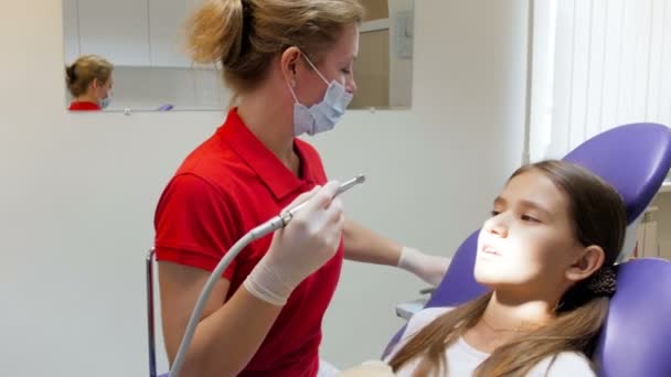 Vidéo 4k montrant une dentiste enlevant des caries avec une perceuse dentaire sur des dents d'adolescentes
 - Séquence, vidéo