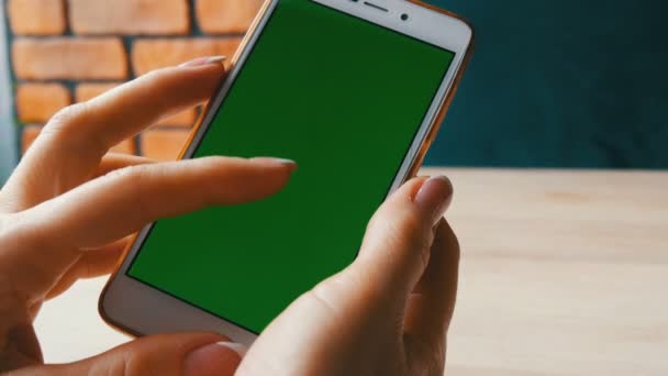 Zöld képernyő smartphone. Chroma Key egy fehér okostelefon, női kezek hold mozgatható telefon-ban egy kávézó - Felvétel, videó