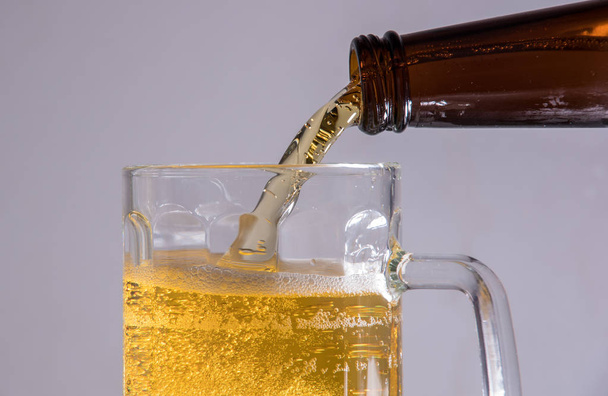 Beer in a glass poured from a bottle thrown from the ice and foam - Fotografie, Obrázek