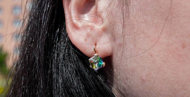 brincos com a bela pedra na orelha
 - Foto, Imagem