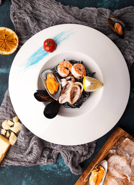 красива порція чорної макарони з каракатицьким чорнилом та морепродуктами, креветками, мідіями, кальмарами
 - Фото, зображення